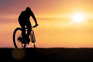 silhouetten van mountainbikes en fietsers in de avond gelukkig. reis- en fitnessconcept foto