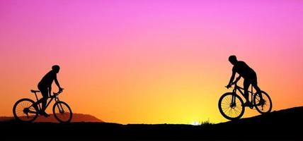 silhouet van een mountainbiker die bergafwaarts geniet tijdens de zonsondergang. mountainbike-concept. mountainbike race - silhouet wielrenner op de achtergrond. foto