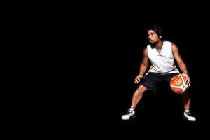 gebaar van Aziatische basketbalspeler dribbelen op zwarte achtergrond. basketbalconcept in Azië foto