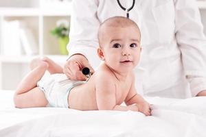 de arts die baby onderzoekt met stethoscoop