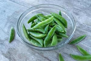 kom vol groene peultjes plat leggen foto