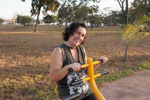 volwassen vrouw die aan het trainen is om in vorm te komen in een openluchtfitnesspark foto
