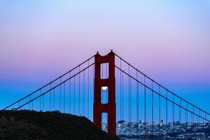 majestueuze san francisco golden gate bridge met juni 2022 volle maan die opkomt en de noordelijke toren gezien vanaf de landtongen van marin in californië foto