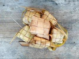 ketupat of rijst knoedel op houten achtergrond. Indonesisch culinair eten foto