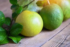 pomelo fruit op houten ondergrond, verse groene pomelo en blad van pomelo-boom, pummelo, grapefruit in zomer tropisch fruit in thailand foto