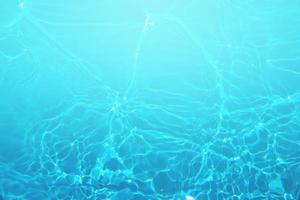 defocus wazig blauwe aquarel in zwembad golfde water detail achtergrond. waterplons, waternevelachtergrond. foto