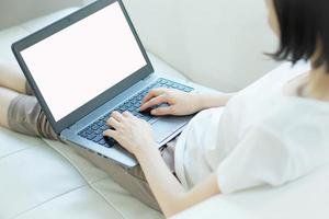 casual jonge vrouw met behulp van laptop in de woonkamer thuis foto