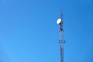 hoge telefoontoren. prachtige lucht met een communicatietoren op de voorgrond foto