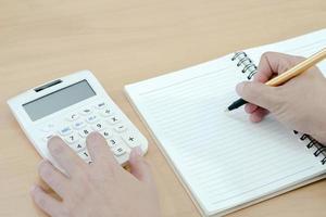 zakenman werken en schrijven op notebook voor zakelijke en boekhoudkundige concept. foto