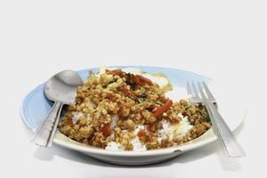 rijst met basilicum, gehakt varkensvlees, gebakken ei, heerlijk en pittig Thais eten is populair over de hele wereld, klaar om te worden geserveerd op een witte achtergrond. foto