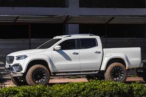 kant turkije 01 maart 2022 witte mercedes benz x klasse is geparkeerd op straat op een warme zomerdag tegen de achtergrond van een buildung, bomen foto