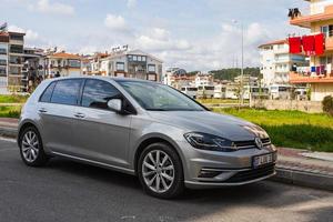 kant turkije 01 maart 2022 grijze volkswagen golf staat op een zomerdag op straat geparkeerd tegen de achtergrond van een buildung, bomen, winkels foto