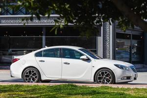 kant turkije 01 maart 2022 witte opel insignes is geparkeerd op straat op een warme dag tegen de achtergrond van een buildung, park foto