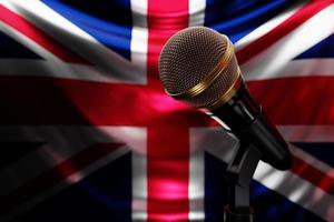 microfoon op de achtergrond van de nationale vlag van het verenigd koninkrijk, realistische 3d illustratie. muziekprijs, karaoke, radio en geluidsapparatuur voor opnamestudio's foto