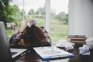 jonge gefrustreerde vrouw die op kantoor werkt foto