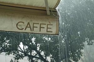 extreem weer - zware regen gezien vanuit een café in rome, italië foto