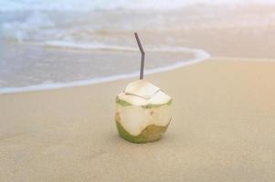 verse kokosnoot met rietje op het strand, reizen en vakantie concept. foto