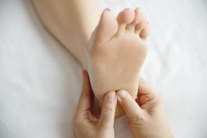 vrouw die voetmassage krijgt van masseuse close-up bij hand en voet - ontspan in voetmassage therapie dienstverleningsconcept foto