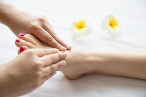 vrouw die voetmassage krijgt van masseuse close-up bij hand en voet - ontspan in voetmassage therapie dienstverleningsconcept foto