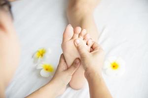 vrouw die voetmassage krijgt van masseuse close-up bij hand en voet - ontspan in voetmassage therapie dienstverleningsconcept foto