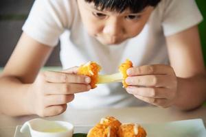 jongen klaar om plakkerige gefrituurde kaasbal te eten - mensen en heerlijk kaasvoedselconcept foto