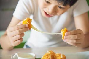 jongen klaar om plakkerige gefrituurde kaasbal te eten - mensen en heerlijk kaasvoedselconcept foto