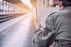 reizen man wacht trein op perron - mensen vakantie levensstijl activiteiten bij treinstation vervoer concept foto