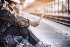 reizen man wacht trein op perron - mensen vakantie levensstijl activiteiten bij treinstation vervoer concept foto