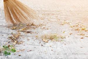 man die de buitenweg schoonmaakt met behulp van bloei gemaakt van droog kokosnootverlofproduct - het levensstijlconcept van de lokale bevolking in thailand foto