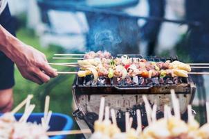 man grill barbecue op hete houtskoolgrill - outdoor tuinfeest concept foto