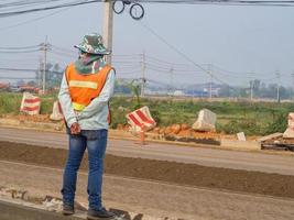 man arbeiders staan om de wegenbouw te controleren foto