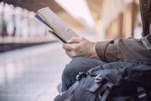 reizen man wacht trein op perron - mensen vakantie levensstijl activiteiten bij treinstation vervoer concept foto