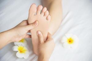 vrouw die voetmassage krijgt van masseuse close-up bij hand en voet - ontspan in voetmassage therapie dienstverleningsconcept foto