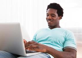 gelukkige jonge man met behulp van laptop