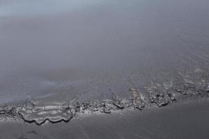 ruwe olie lekkage op het strand foto