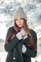 mooie winter portret van een jonge vrouw in het besneeuwde landschap foto