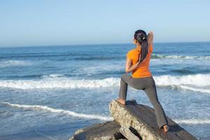 Kaukasische vrouw het beoefenen van yoga aan kust foto