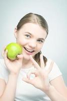 gezond eten: Kaukasisch tienermeisje met groene appel foto