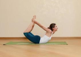 Kaukasische vrouw beoefent yoga in studio (dhanurasana)