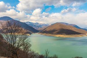 Kaukasische bergen in de buurt van het groene meer en verbazingwekkende wolken foto