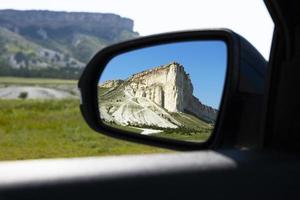 prachtige bergen, witte rotsen, dieren in het wild in de achteruitkijkspiegel van de auto. foto