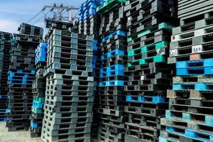 stapel plastic verzendpallet. industriële kunststof pallet gestapeld in fabrieksmagazijn. vracht- en verzendingsconcept. kunststof palletrek voor de exportbezorgingsindustrie. kunststof pallet opslag magazijn. foto