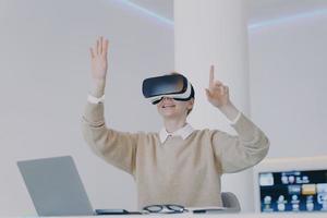 europees meisje in vr-headset klik op knoppen in virtual reality. werken aan een project voor visuele effecten. foto