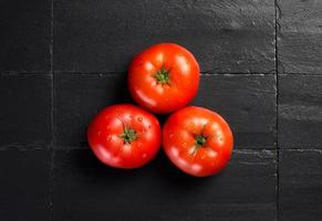 verse en gezonde tomaten over zwarte leisteen
