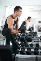 man doet oefeningen halter biceps spieren foto