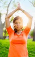 actieve vrouw doet yoga houdingen bij zonsondergang