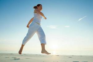 blanke vrouw joggen aan de kust foto