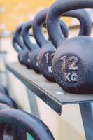 kettlebells rijen met verschillende gewichten in het fitnesscentrum foto