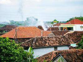 een foto van een rokerig dorpslandschap, genomen van bovenaf 's middags