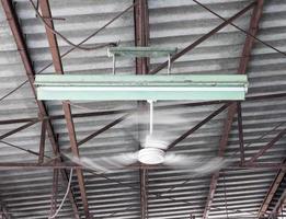 oude plafondventilator beweegt in de buurt van de elektrische lamp. foto
